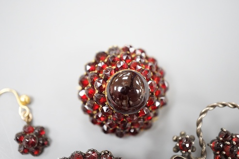A Victorian gilt metal and facetted garnet set cluster brooch, 27mm, two other similar brooches, a bracelet and pair of earrings.